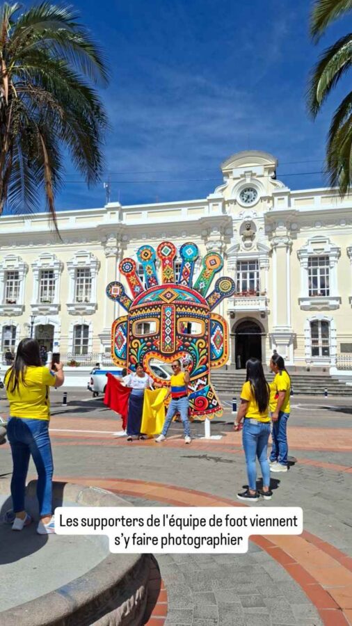 Otavalo, Équateur : des supporters se photographient devant un masque de carnaval